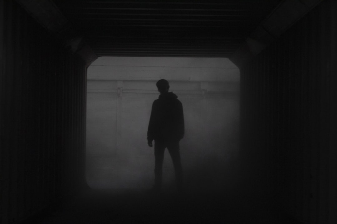 Silhouette of a person standing before a foggy window