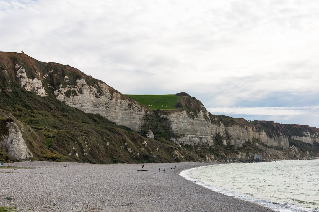 a beach with a cliff and water