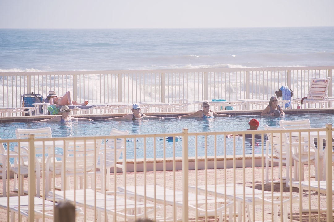 People relaxing in a swimming pool by the ocean