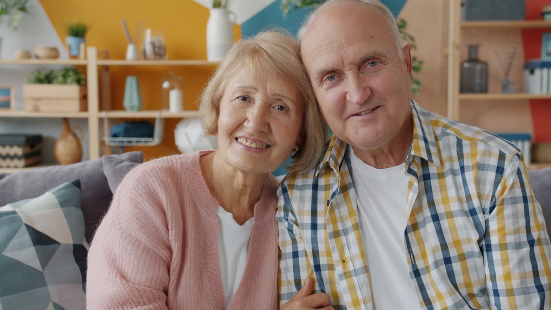Elderly couple smiling together on a couch.