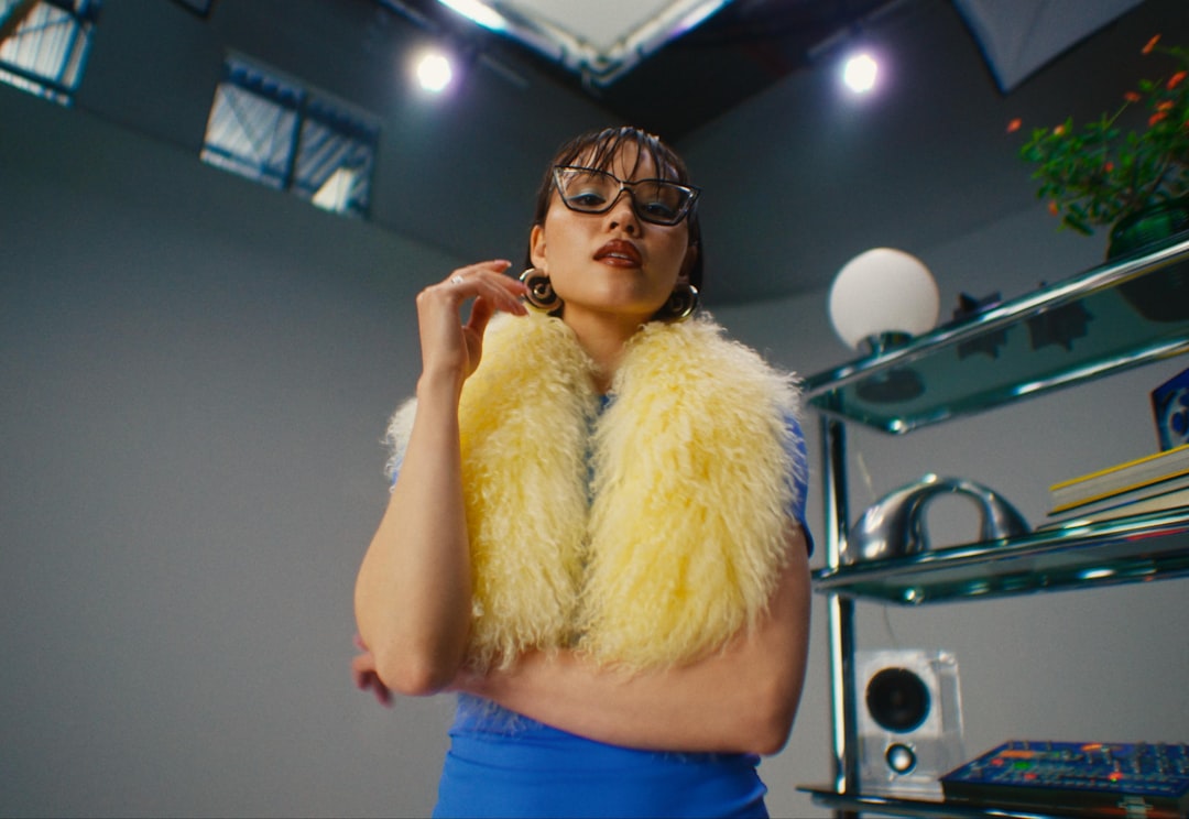 Woman posing in a studio wearing a yellow fur.
