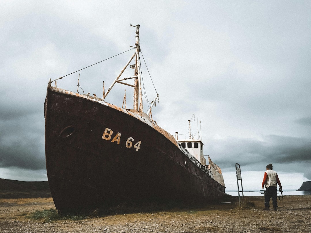 a large boat sitting on top of a dry grass field